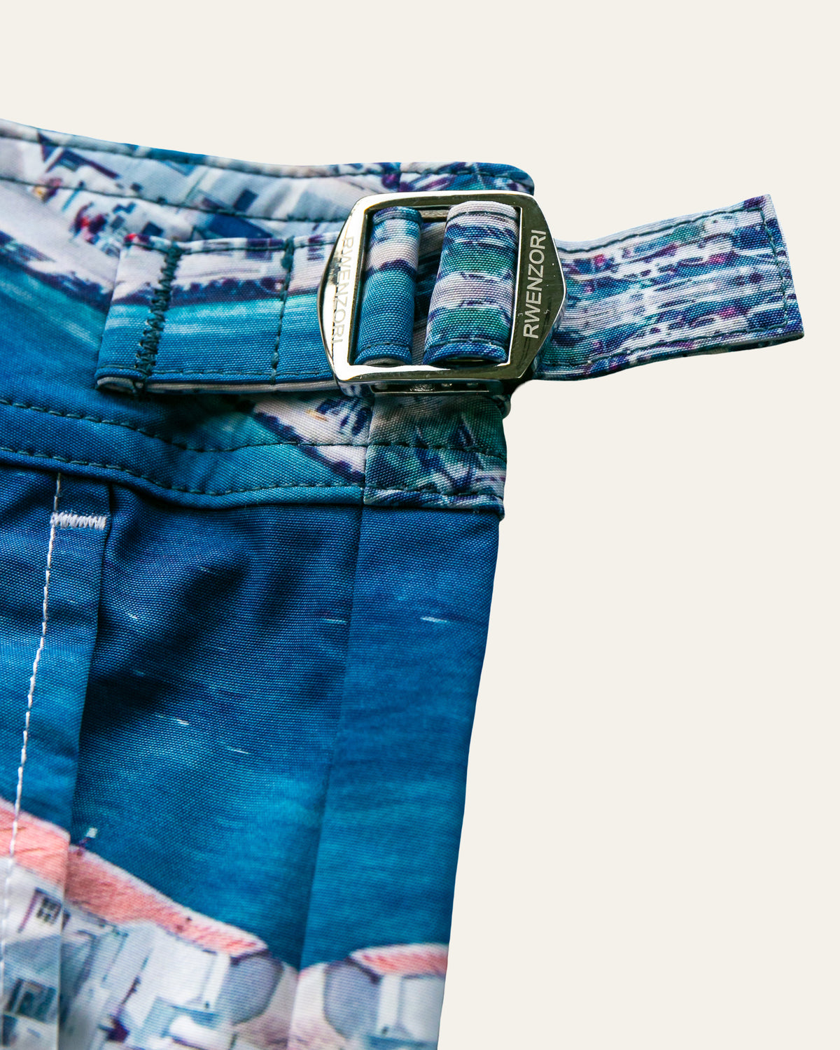 RWENZORI Mykonos photo print swim shorts — stainless steel buckles closeup.