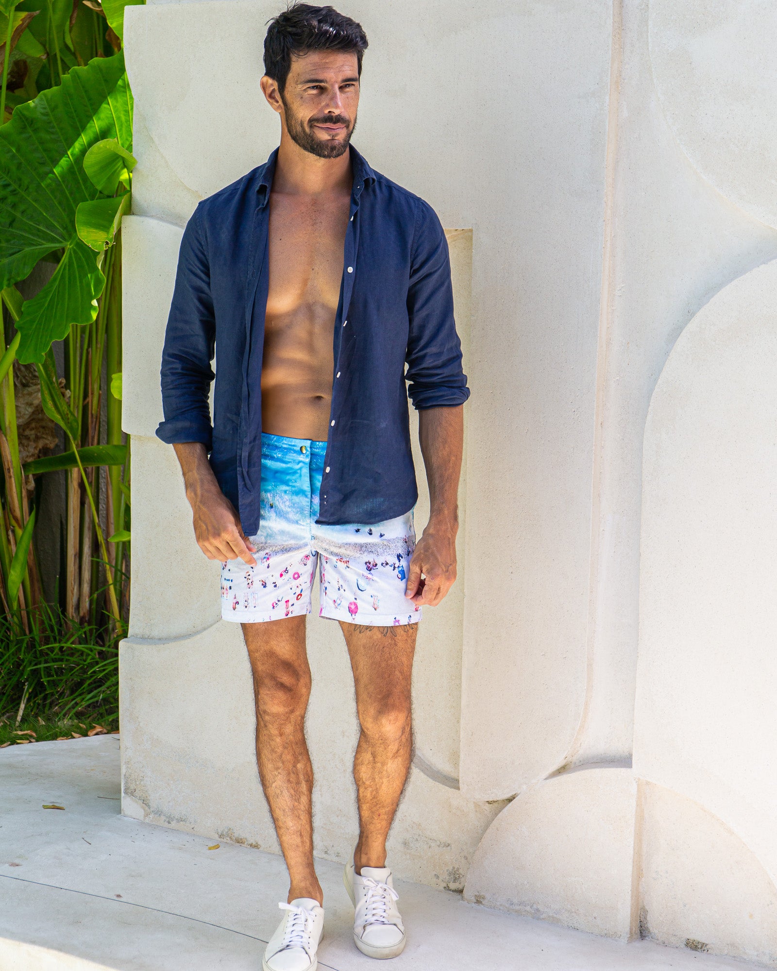 Man wearing Rwenzori Navy linen resort shirt open with French Riviera swim shorts.