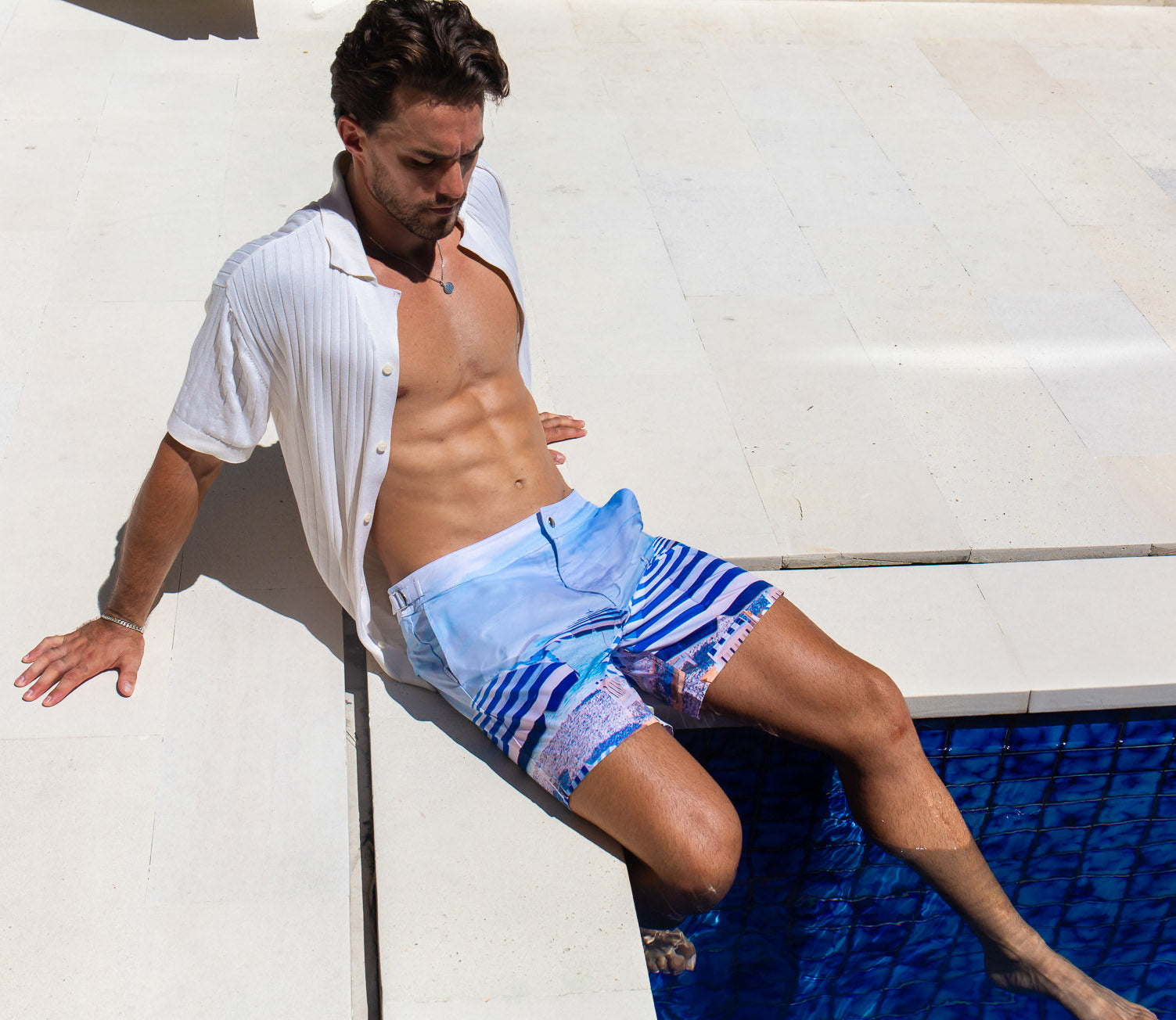Model wearing Rwenzori swim shorts St Tropez at a pool villa in the south of France.