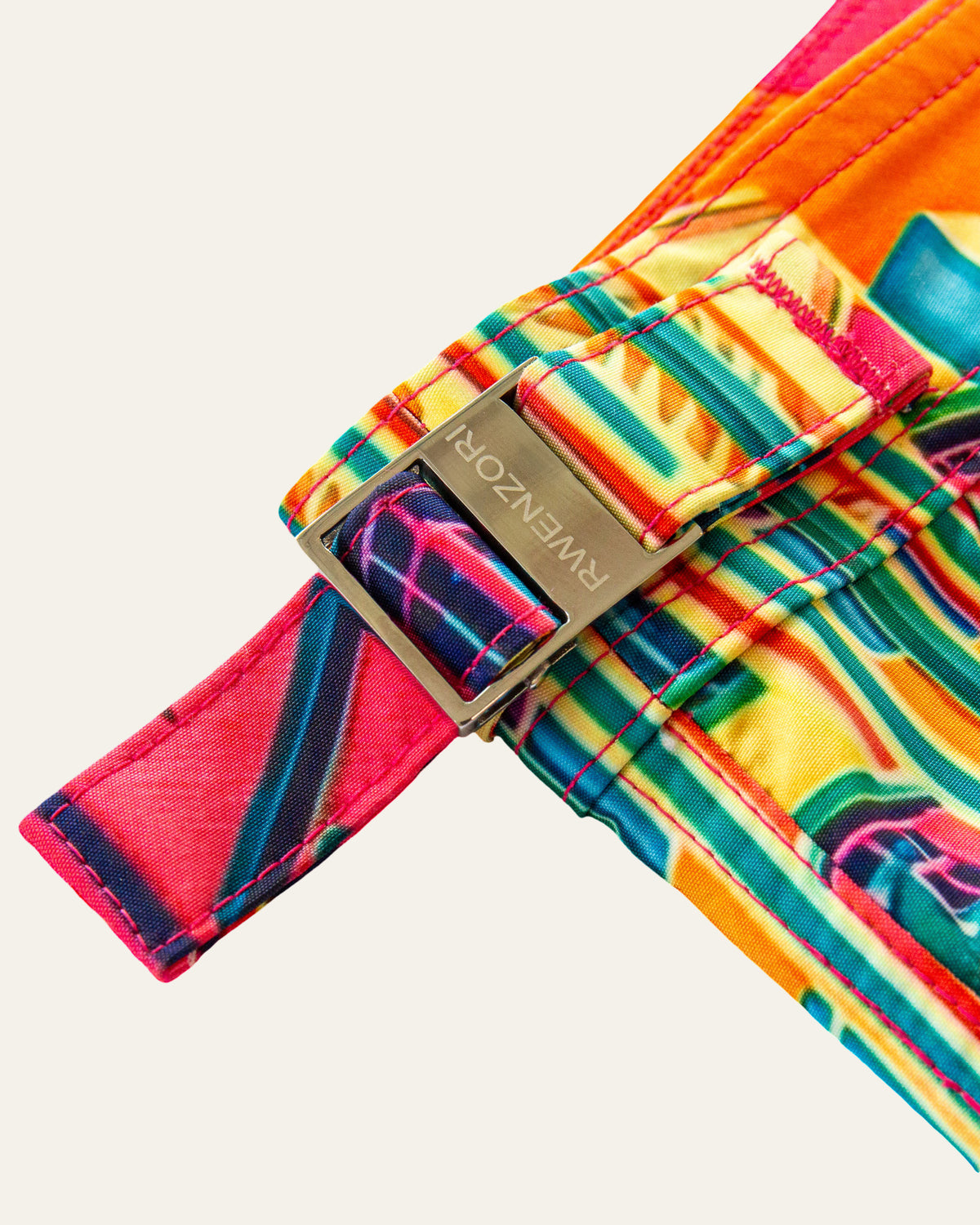 Close-up of the stainless steel buckle hardware on RWENZORI Miami photo print swim shorts.