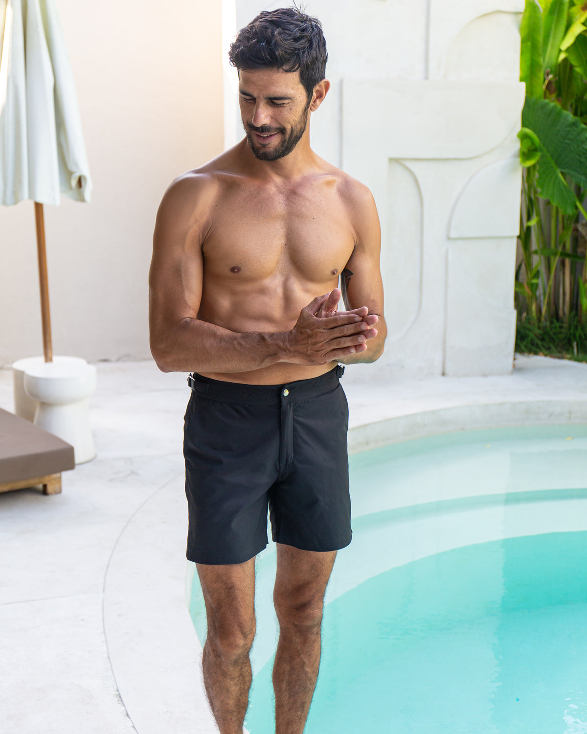 RWENZORI Jet Black Performance Series swim shorts — full-frame front view-poolside.
