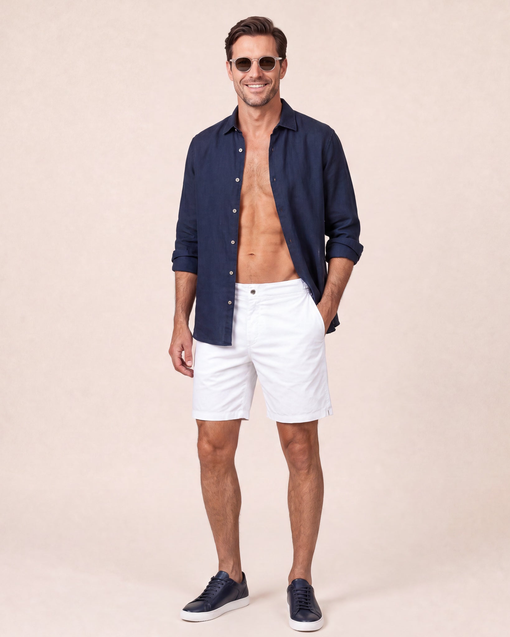 Man wearing RWENZORI Riviera White Performance Series swim shorts with an open navy linen resort shirt.