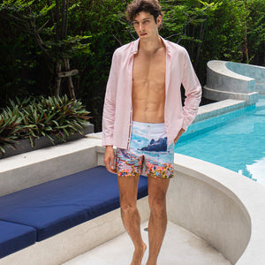 Model wearing Rwenzori Cinque Terre men’s swim shorts at Italian-style villa by pool and lounge Italy showcasing the ultimate resort wear shorts.
