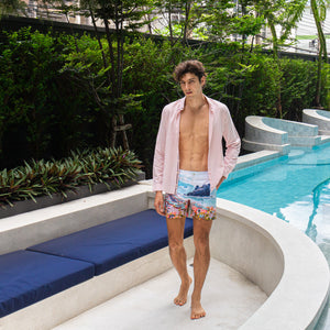 Model wearing Rwenzori Cinque Terre men’s swim shorts at Italian-style villa by pool and lounge Italy showcasing the ultimate resort wear shorts.
