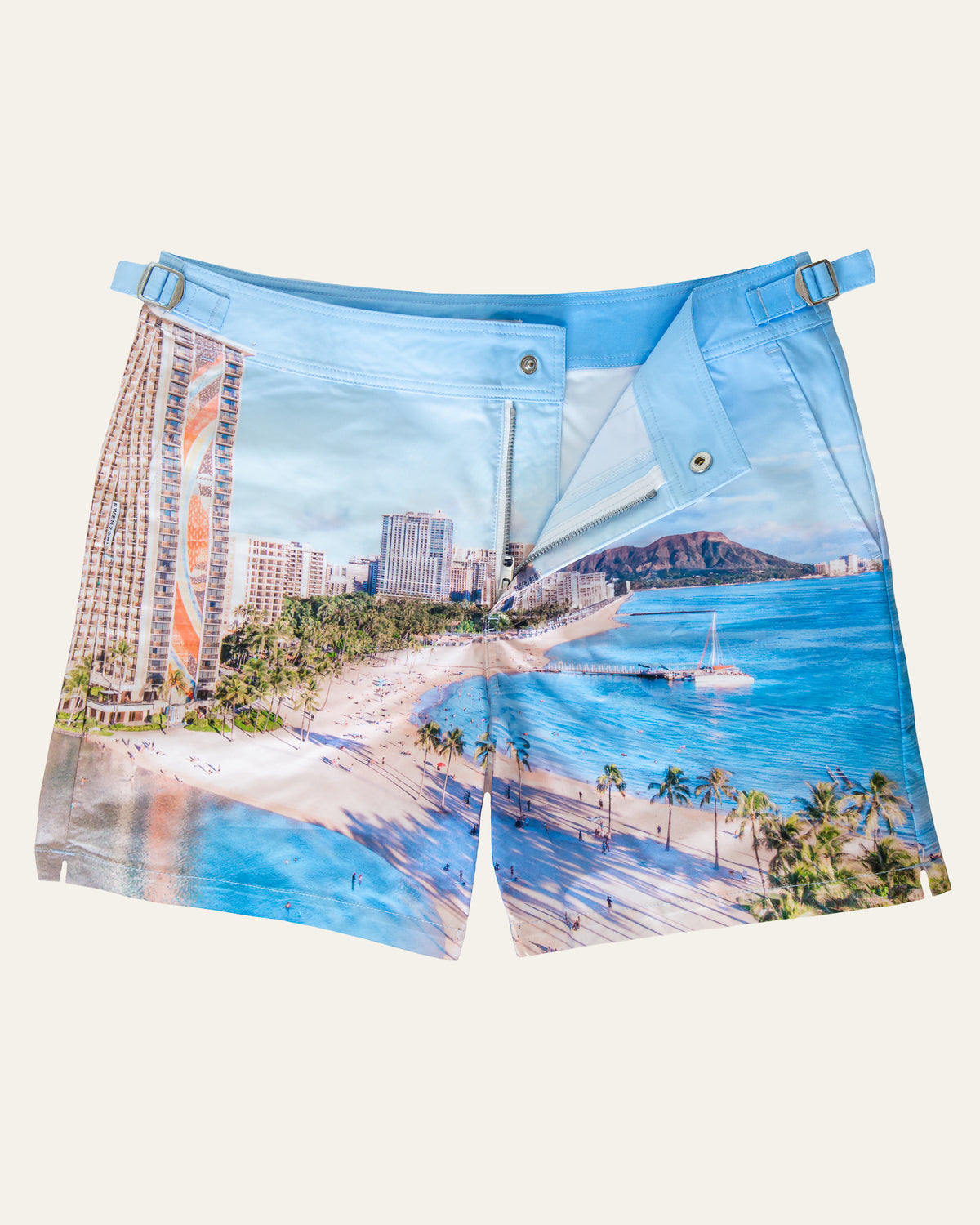 Flat lay front view of RWENZORI Waikiki photo print swim shorts on a clean background.