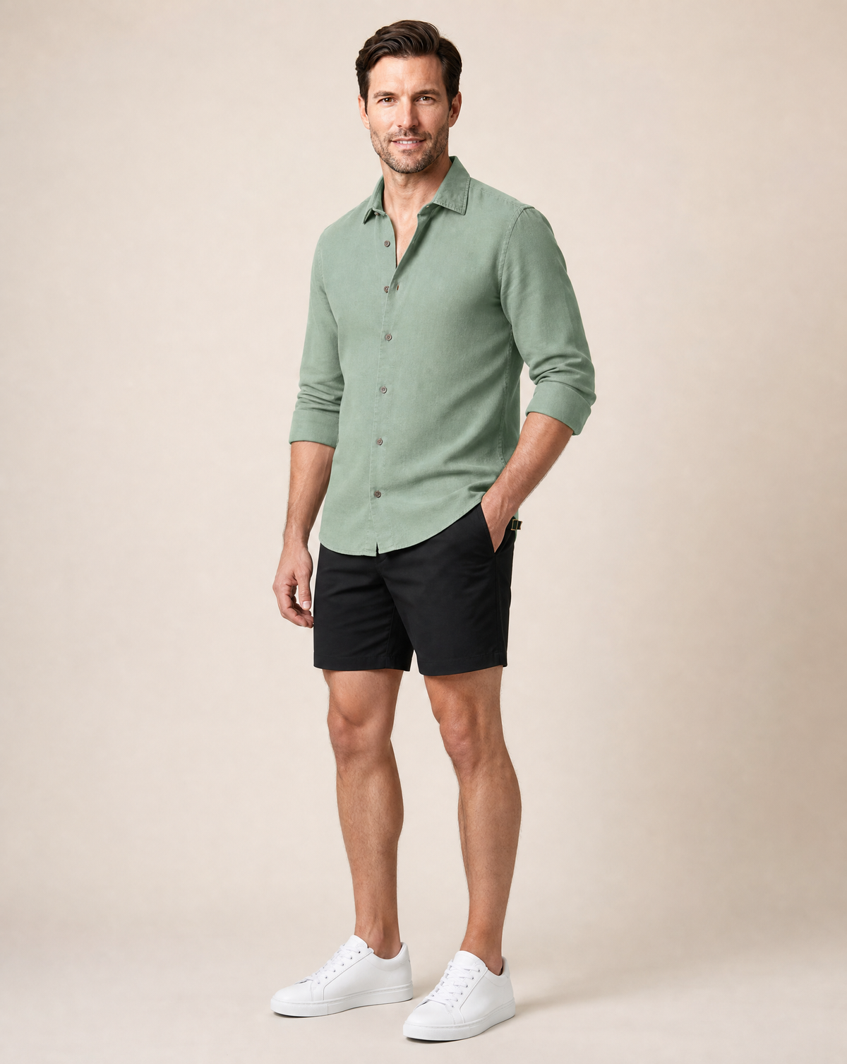 Rwenzori men's sage linen shirt styled with black shorts and white sneakers, casual summer outfit.