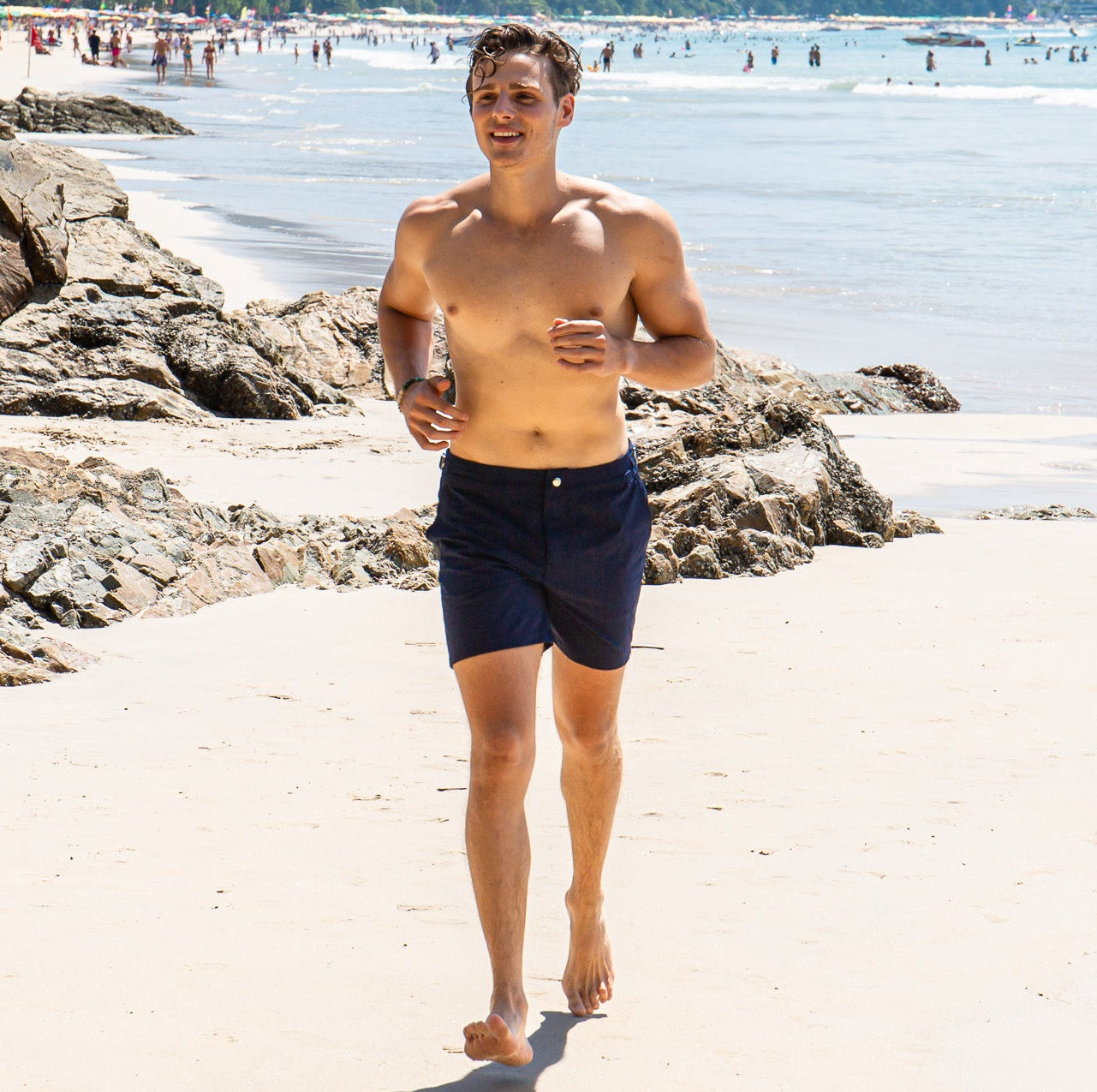 Rwenzori mens performance series swim shorts Nautic Navy worn by model running on beach.