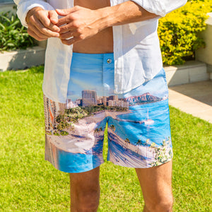 Close-up of Rwenzori Waikiki men’s swim shorts worn by model, showing detailed Hawaii print fabric